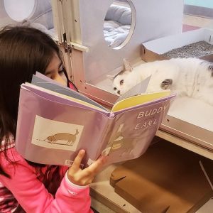 girl reading to cat